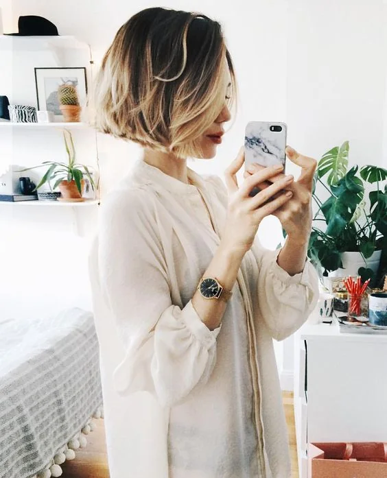 Refresh your classic boy bob haircut with cool hair coloring, here blonde highlights in dark hair and much volume.