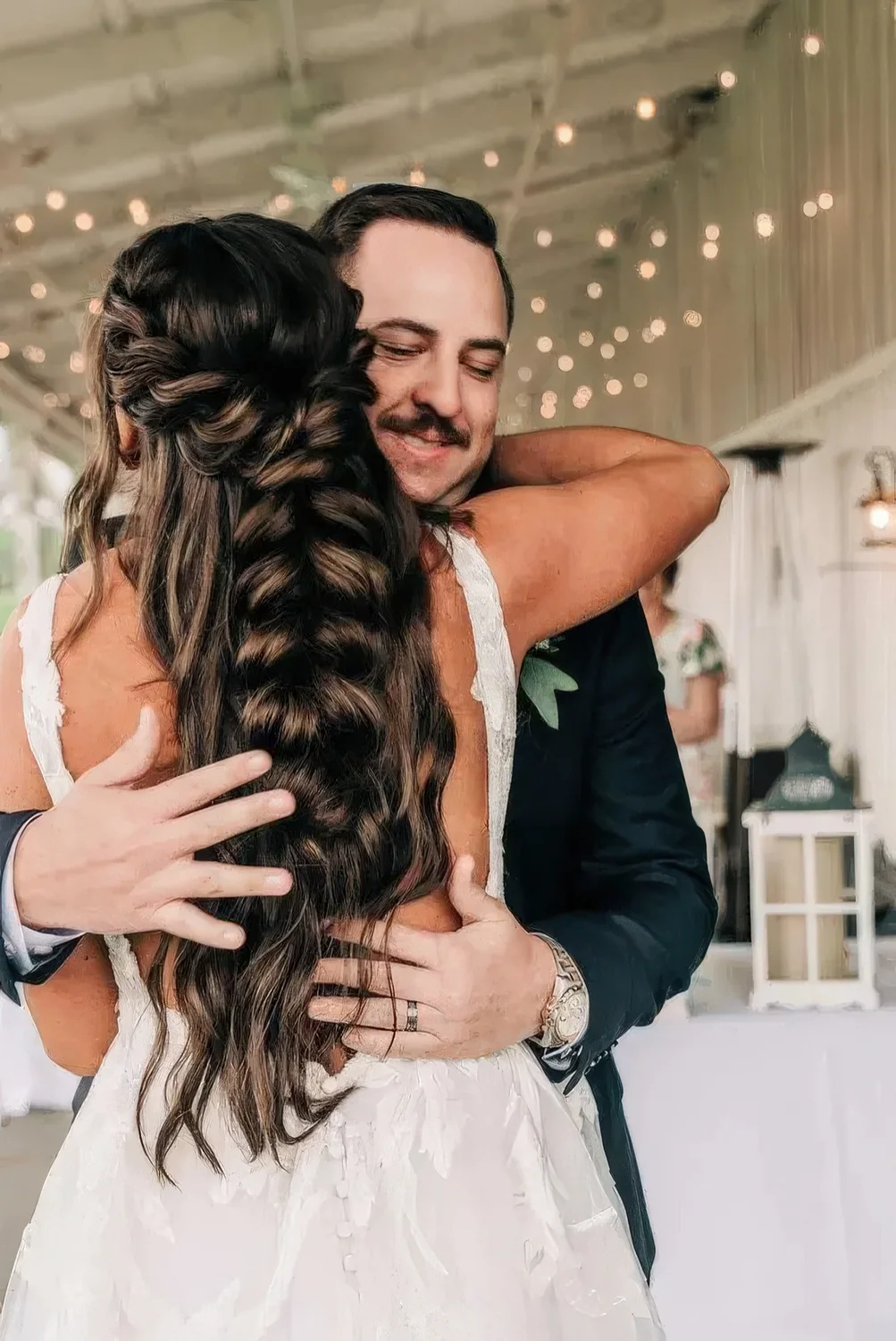 Braided half updo with a large dutch braid halo coming down into one single braid and waves down.