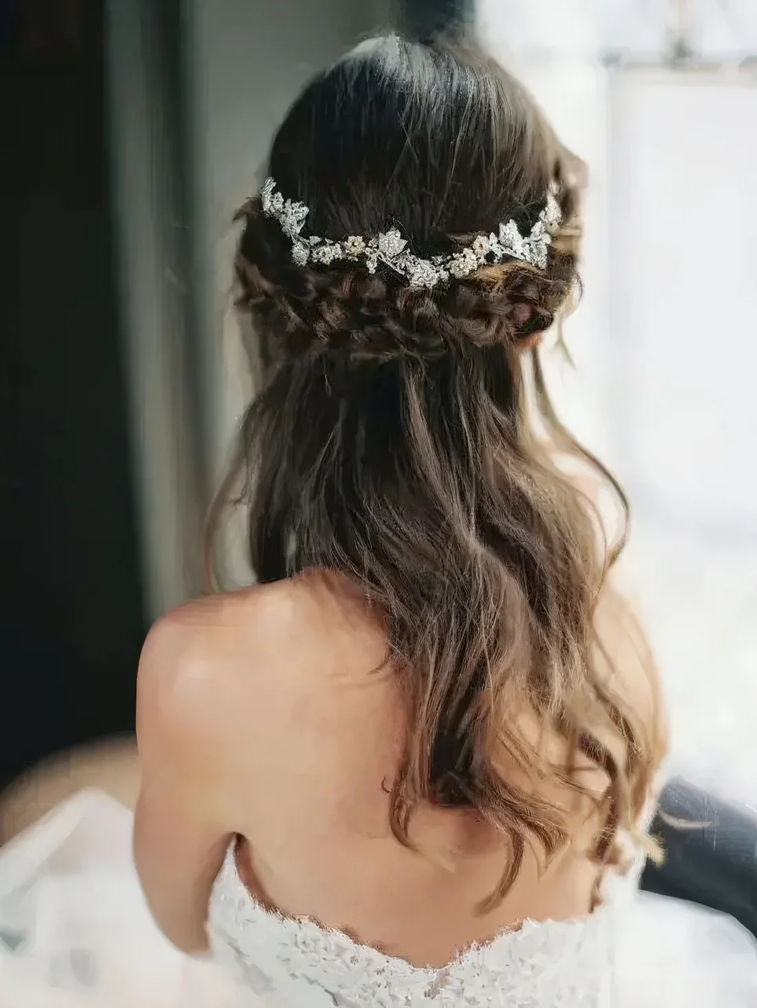Half-up hairstyle with a thick braided halo and a chic rhinestone floral hair vine.