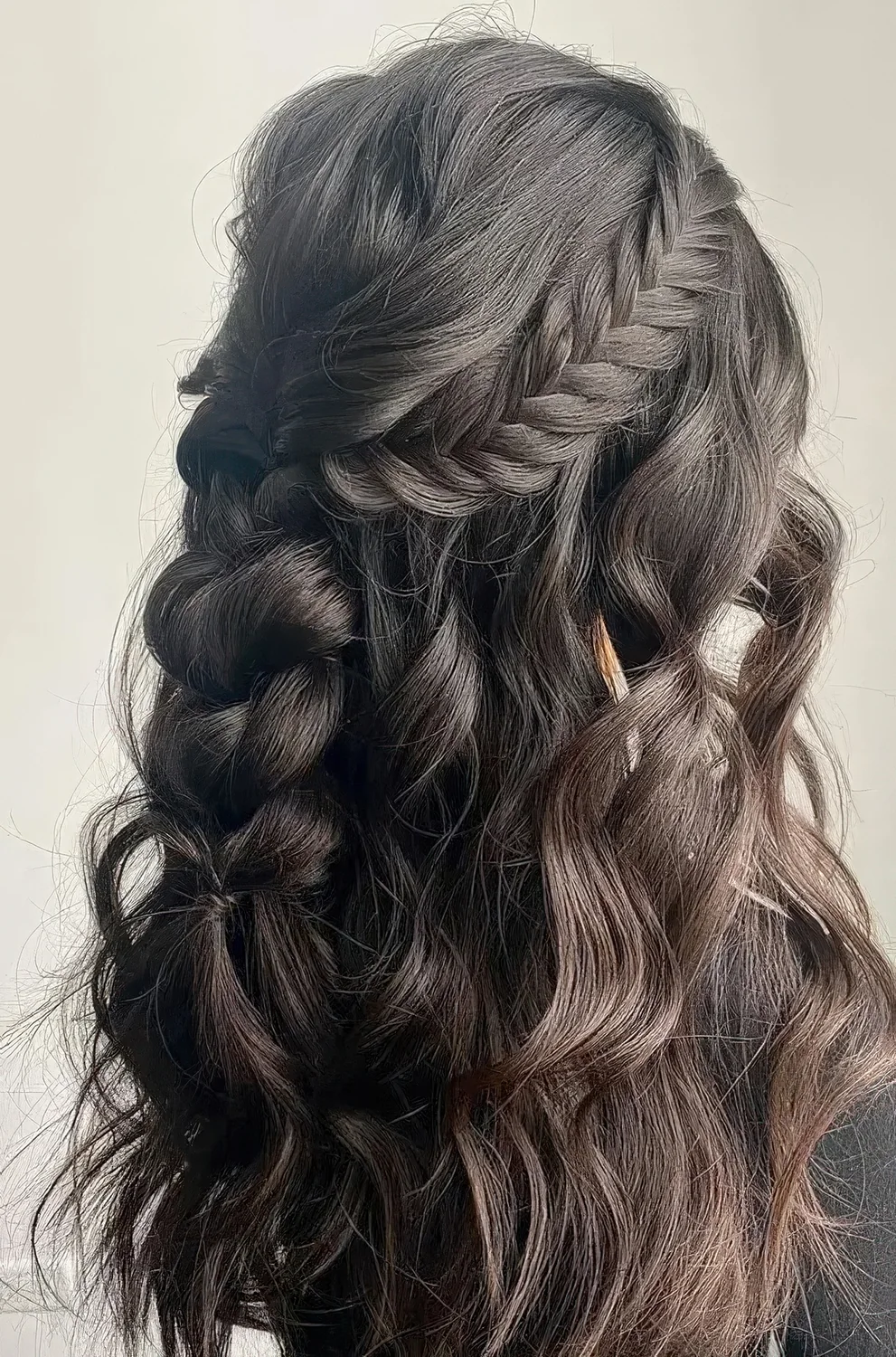 Boho half updo with a wavy bump, a braided halo and a losse braid down plus some waves.