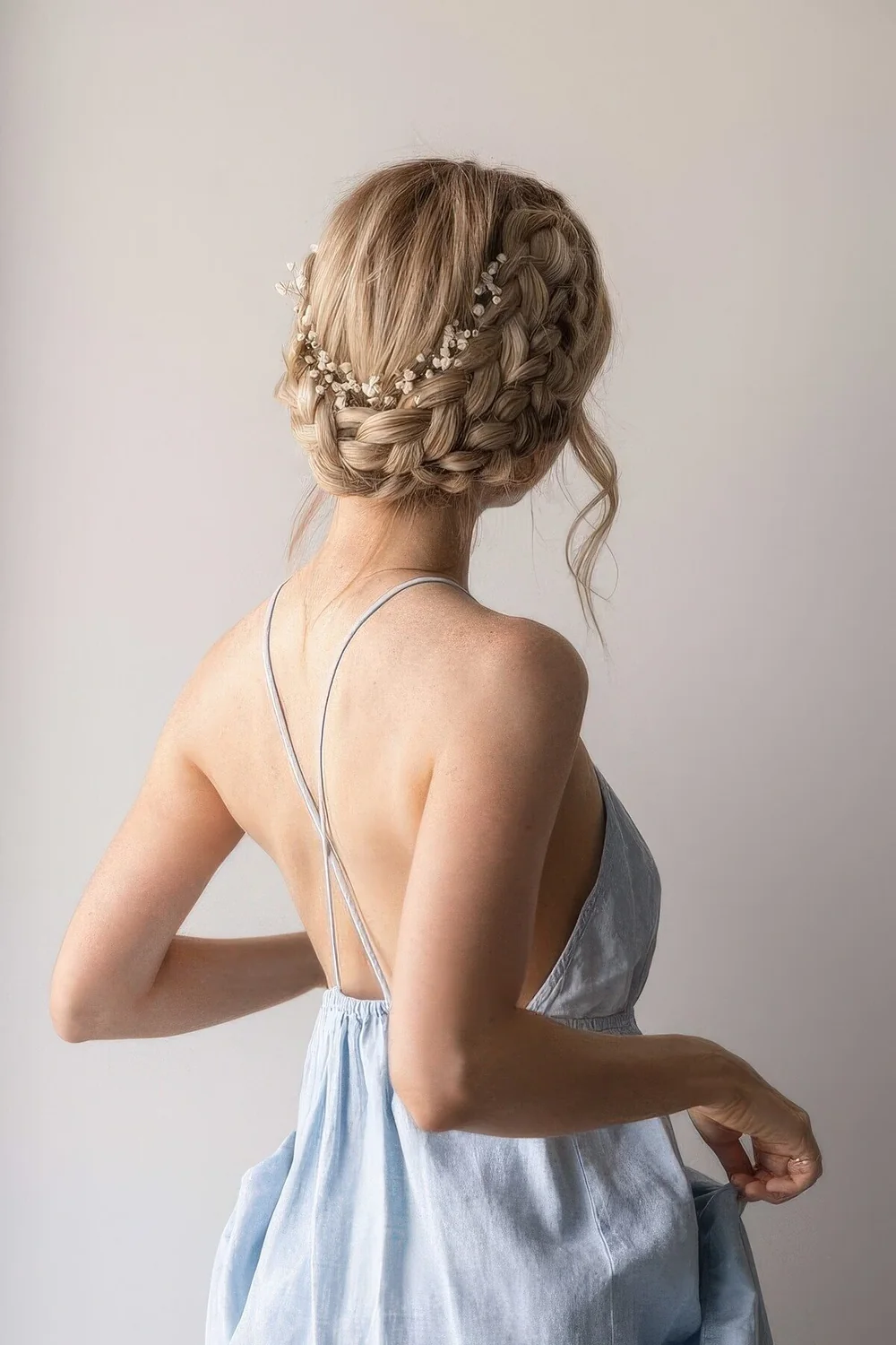 Braided wedding updo with a double braid and some baby's breath.