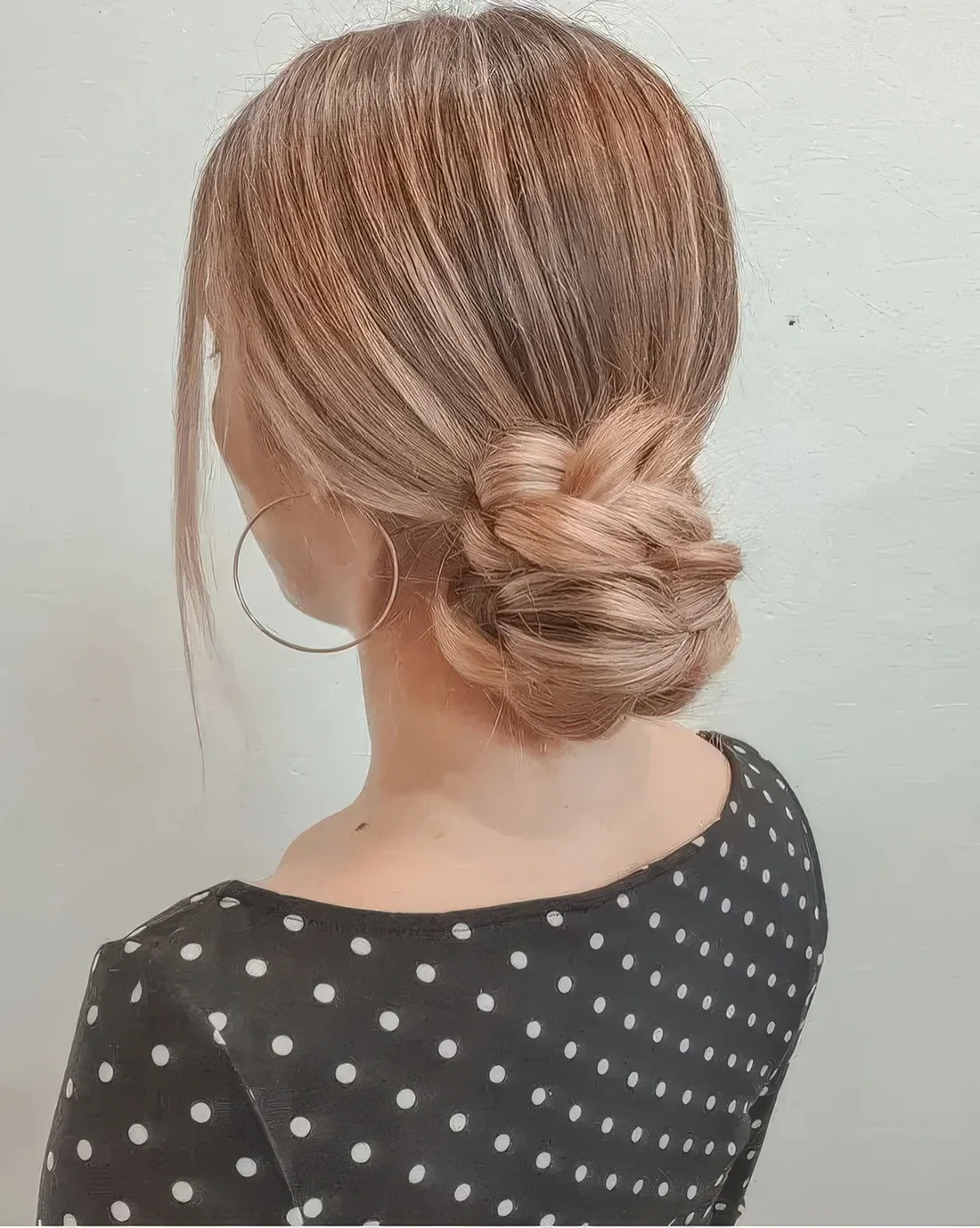 Braided low bun with a sleek top and face-framing hair.
