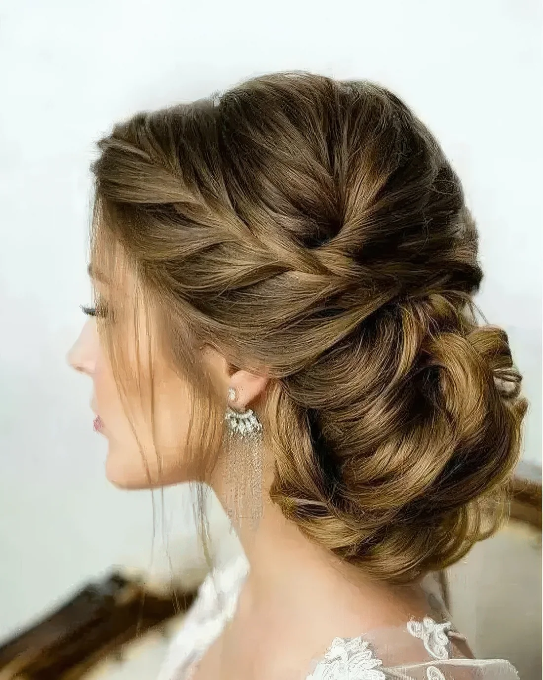 Photo showing braided low side updo, with the hairstyle clearly visible.