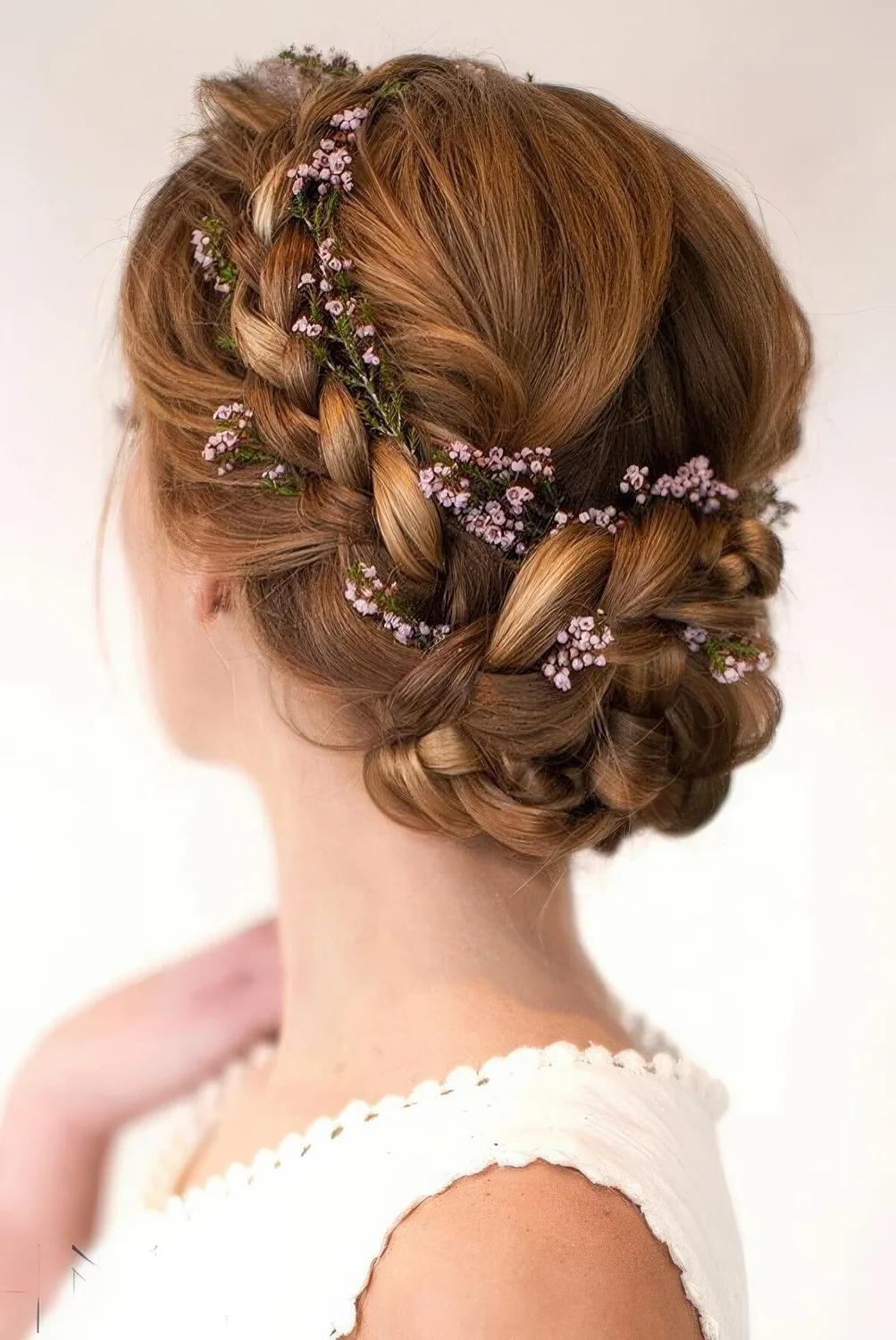 Braided updo with some fresh pink blooms tucked in.