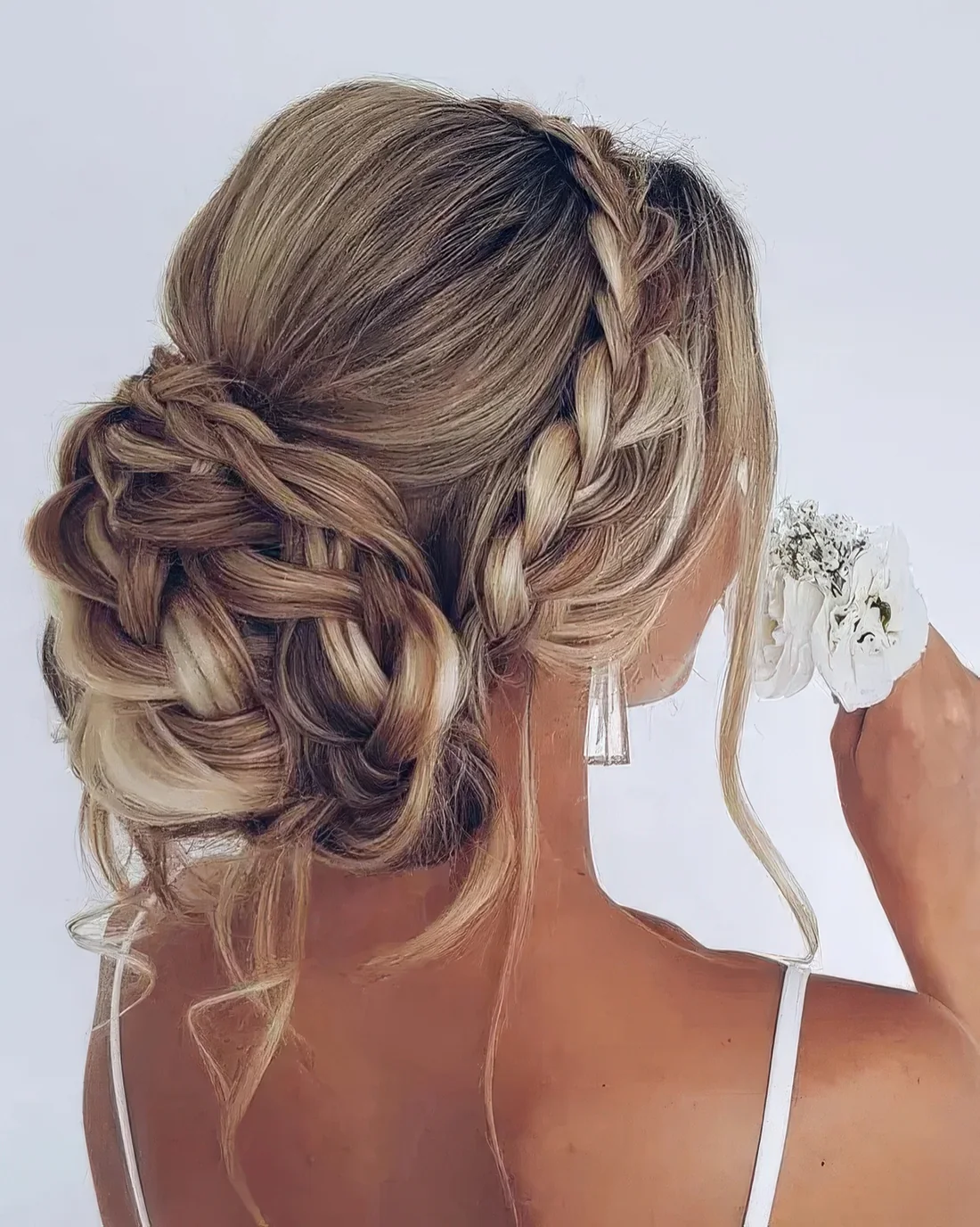 Braided wedding updo with a braided halo, a bump on top and a braided bun plus some locks down.
