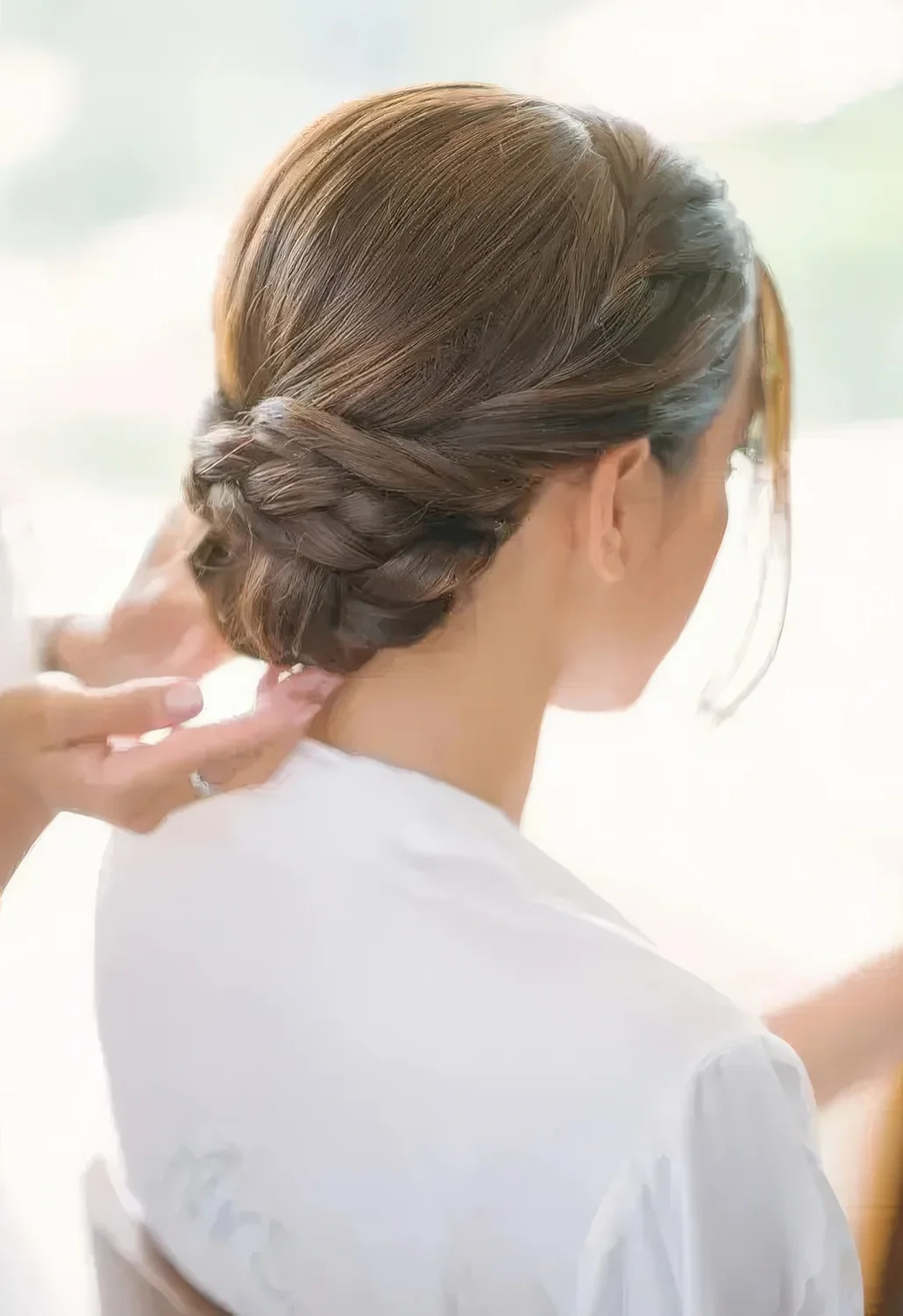 Low twisted and braided bun with a sleek top.