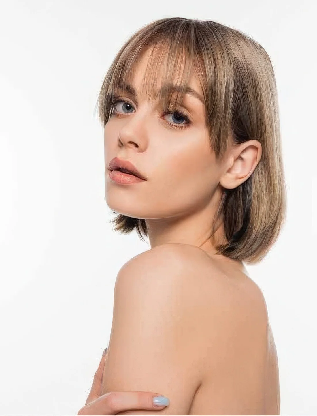 Mousy brown and bronde long bob with wispy and side bangs that beautifully frame the face.