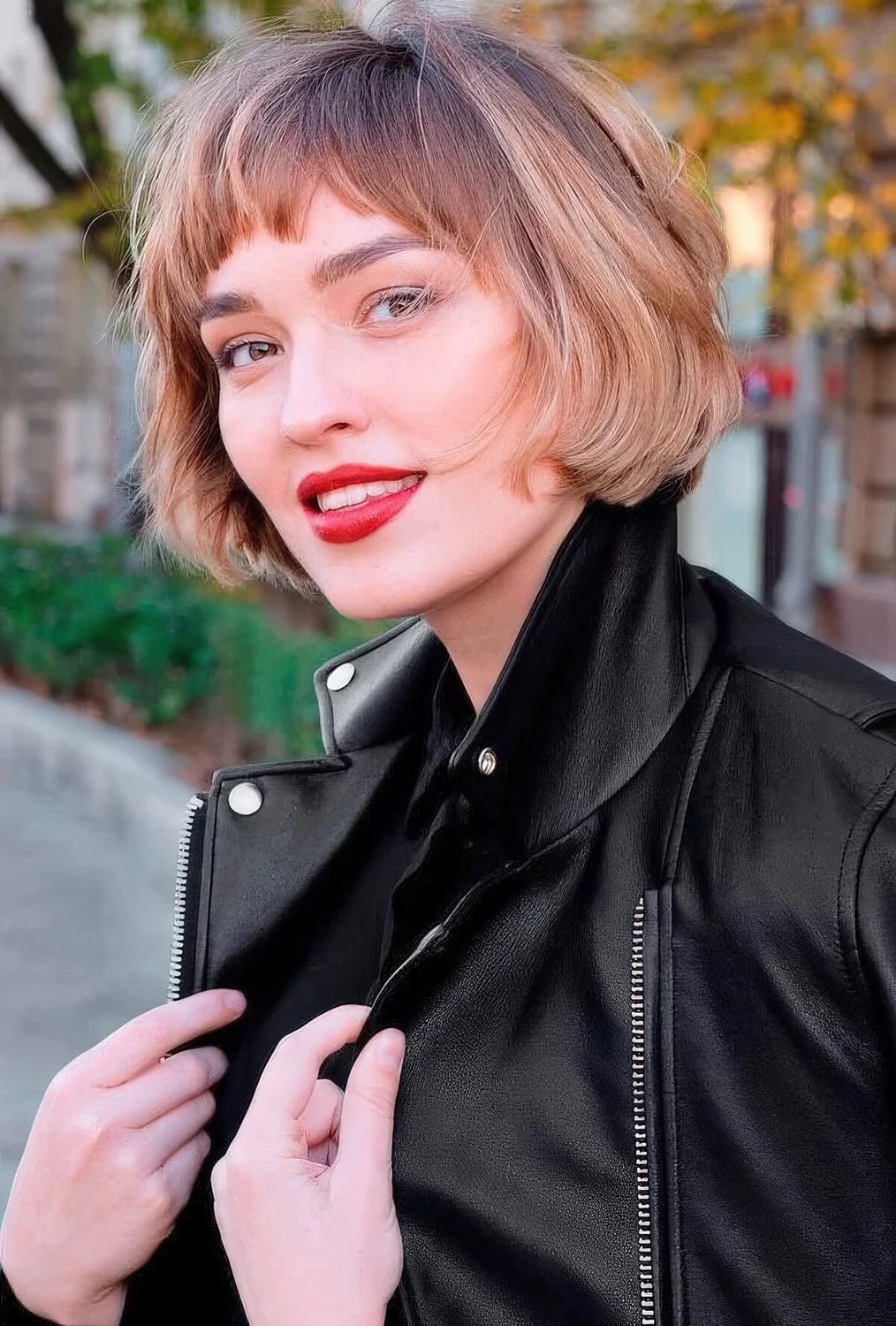 Jaw-length brunette bob with blonde balayage and waves plus bangs.