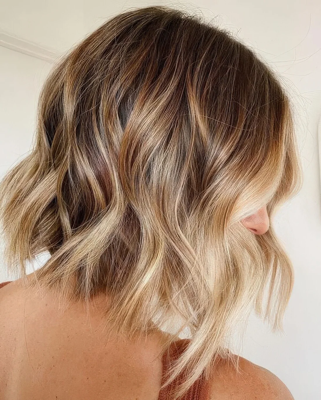 Line bronde wavy bob with a blonde money piece.
