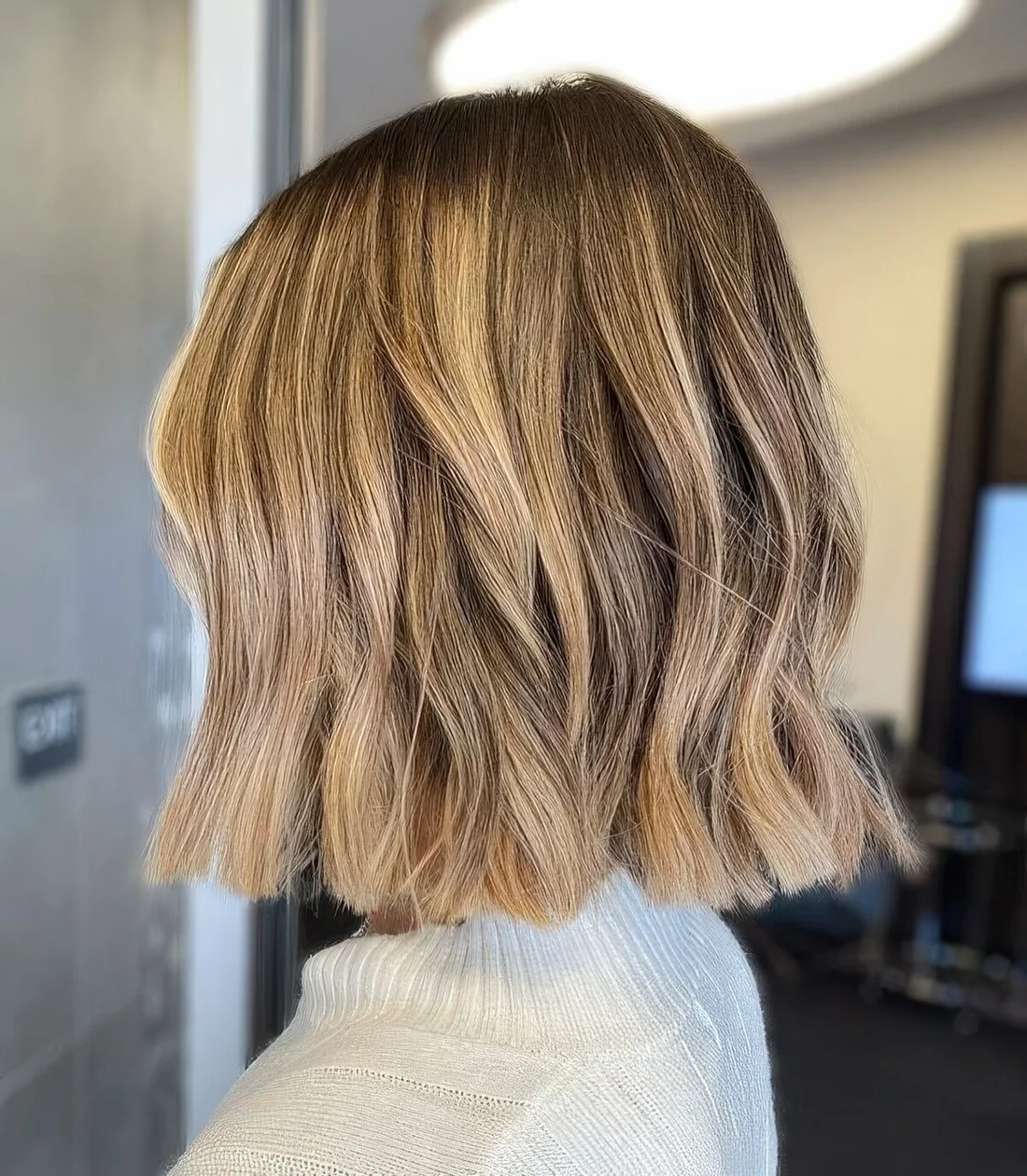 Wavy bronde bob with a darker root and some volume.