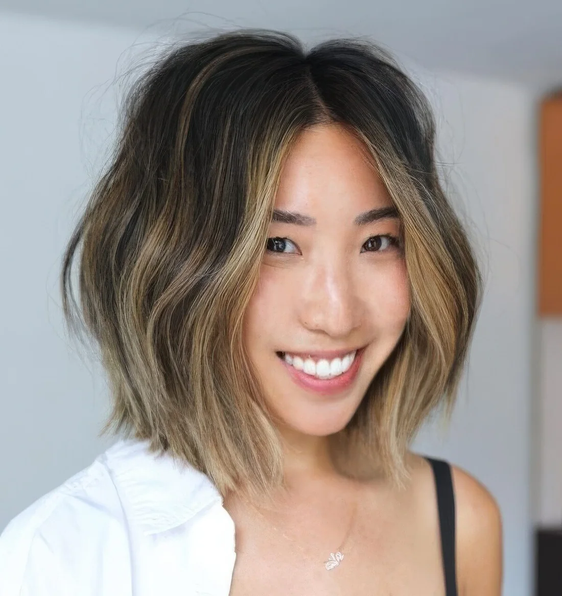 Brunette long bob with blonde balayage and a money piece plus waves.