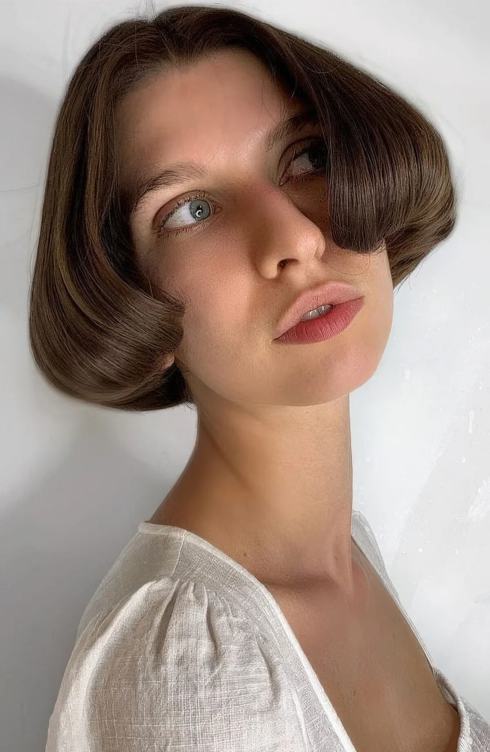Ear-length bob with center part and curved ends.