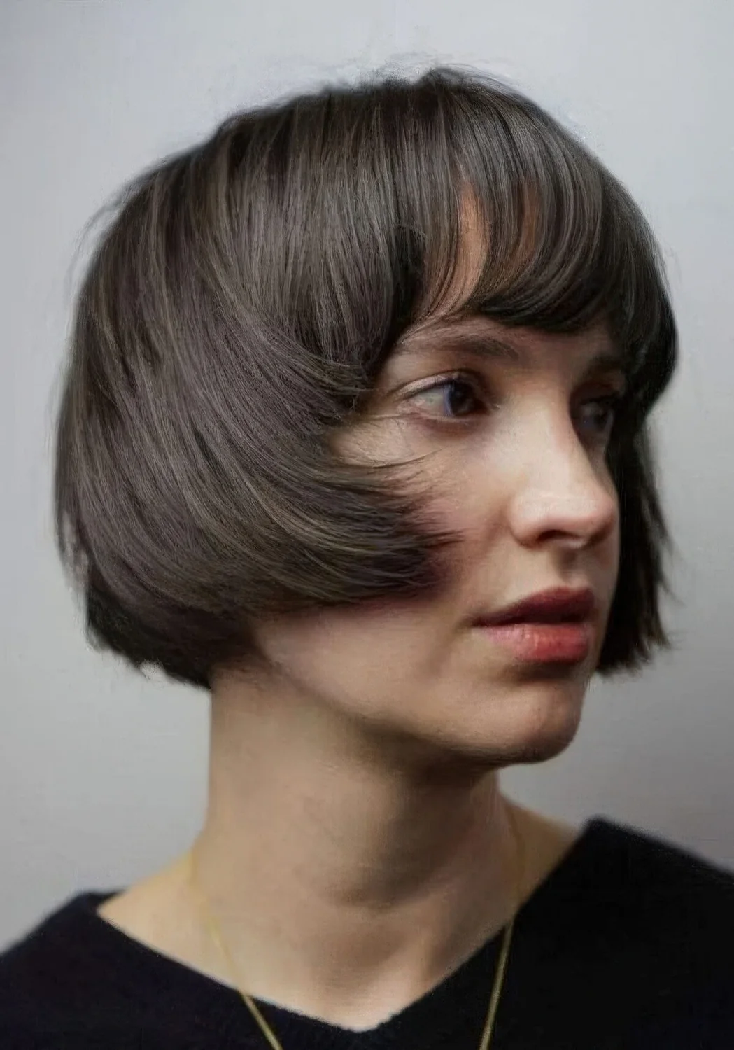 Brunette ear-length bob with a classic fringe and curved ends.