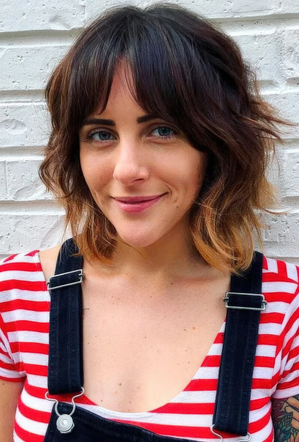 Dark brunette long bob with bottleneck bangs and caramel ombre plus shaggy waves.