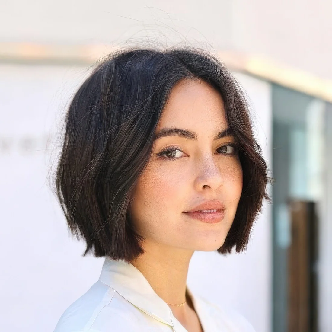 Relaxed brunette midi bob with middle part and slight waves.