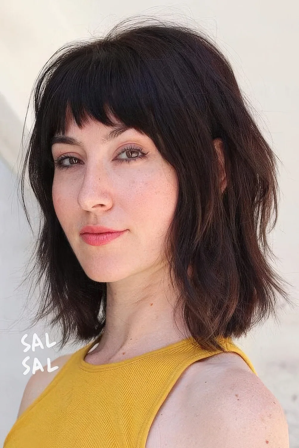 Dark brown long bob with a usual fringe and a shaggy texture.