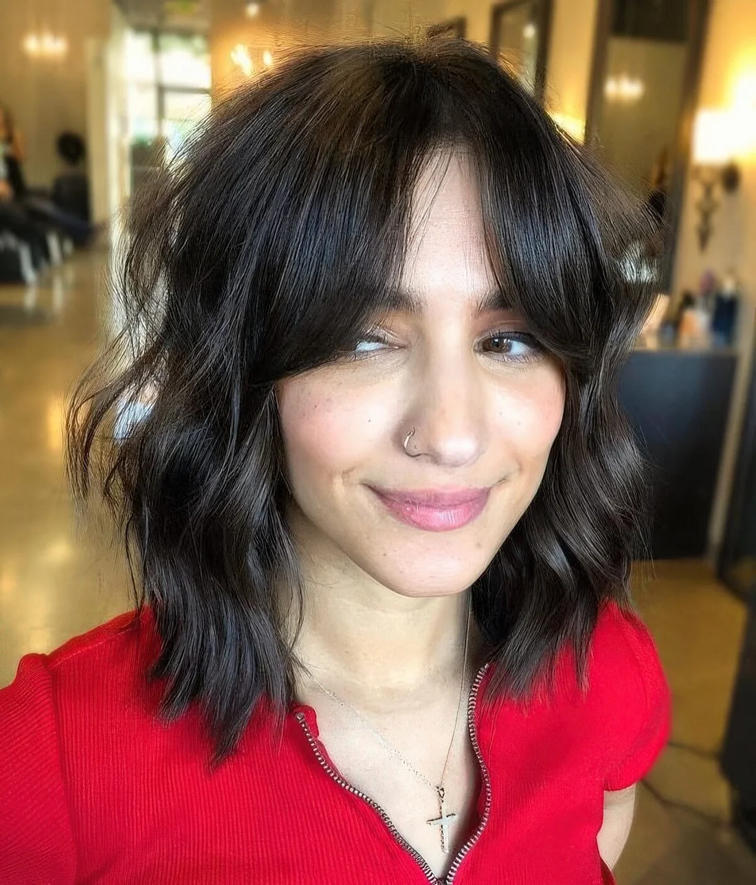 Dark brown shaggy long bob with messy waves and bottleneck bangs.