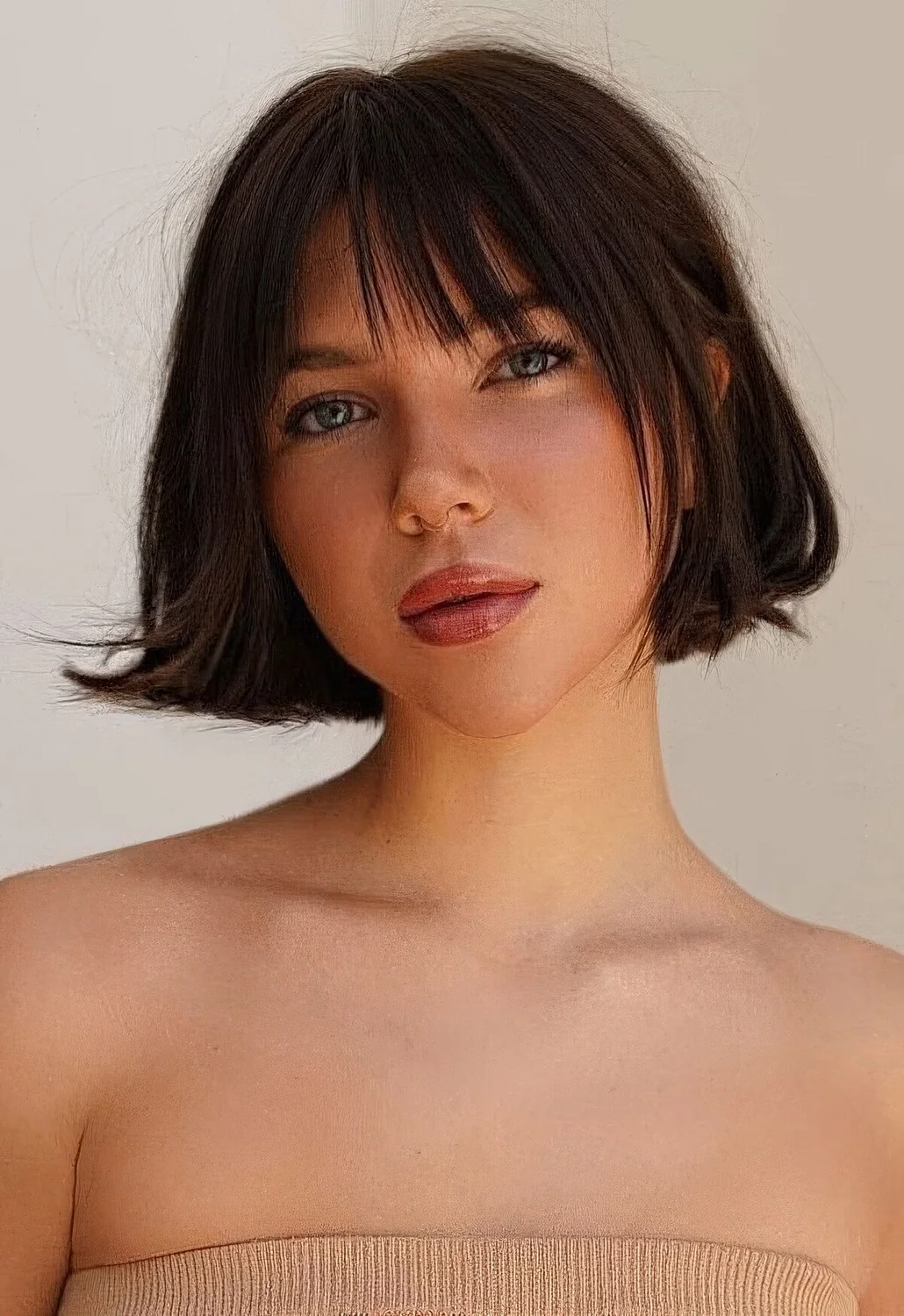 Dark brunette jaw-length bob with face-framing layers and wispy bangs and a bit of volume.