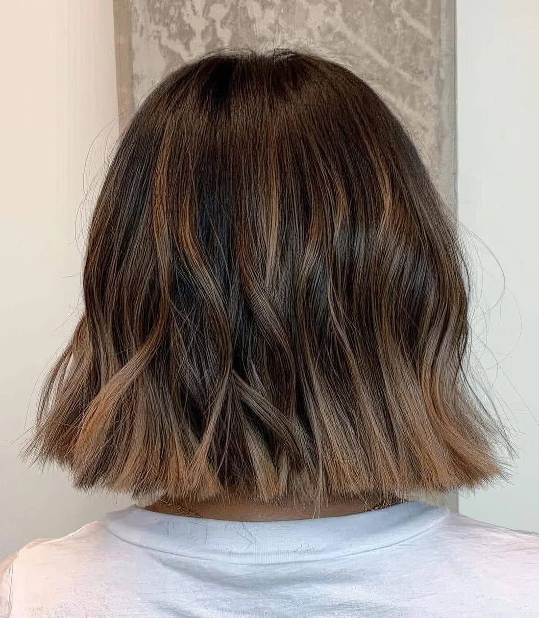 Long brunette bob with caramel balayage and waves.