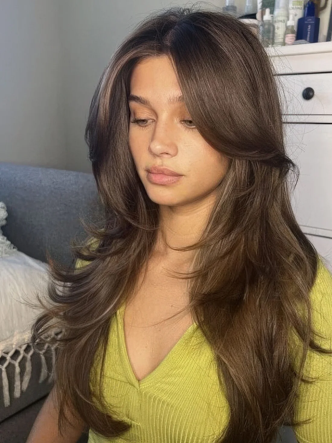 Fab brunette butterfly haircut with long curtain bangs and curled ends.