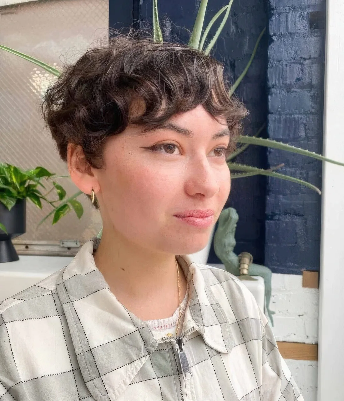 Photo showing brown wavy pixie with bangs, with the hairstyle clearly visible.