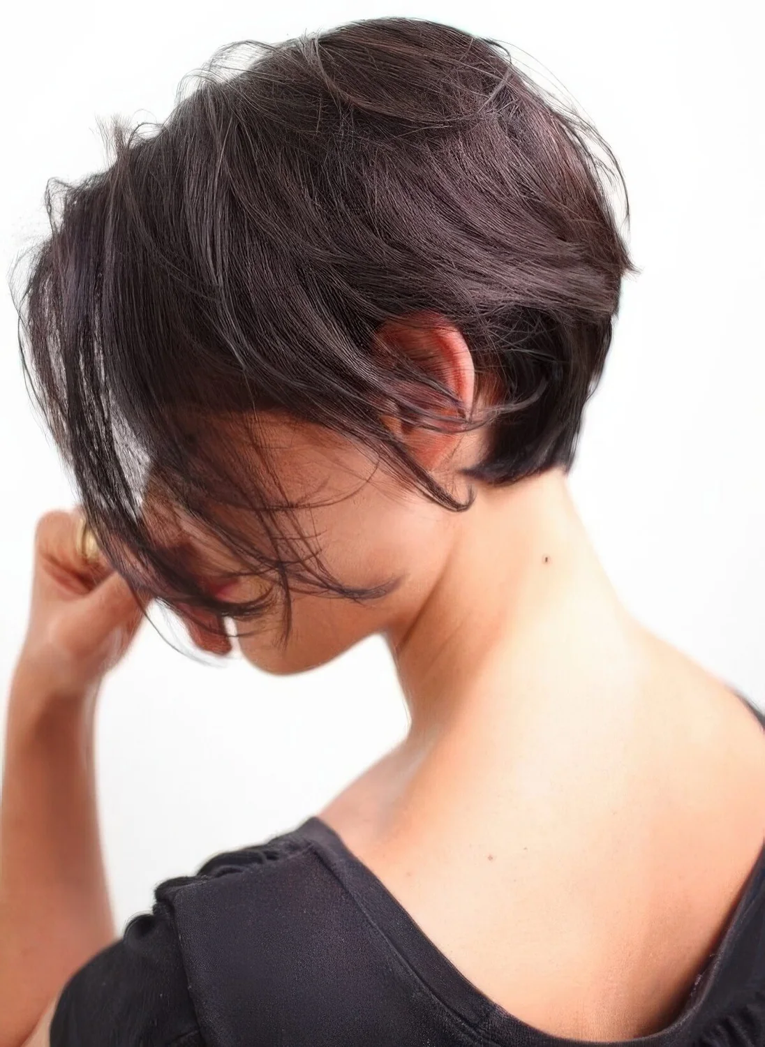 Dark brown textural bixie with long bangs and a lot of volume.
