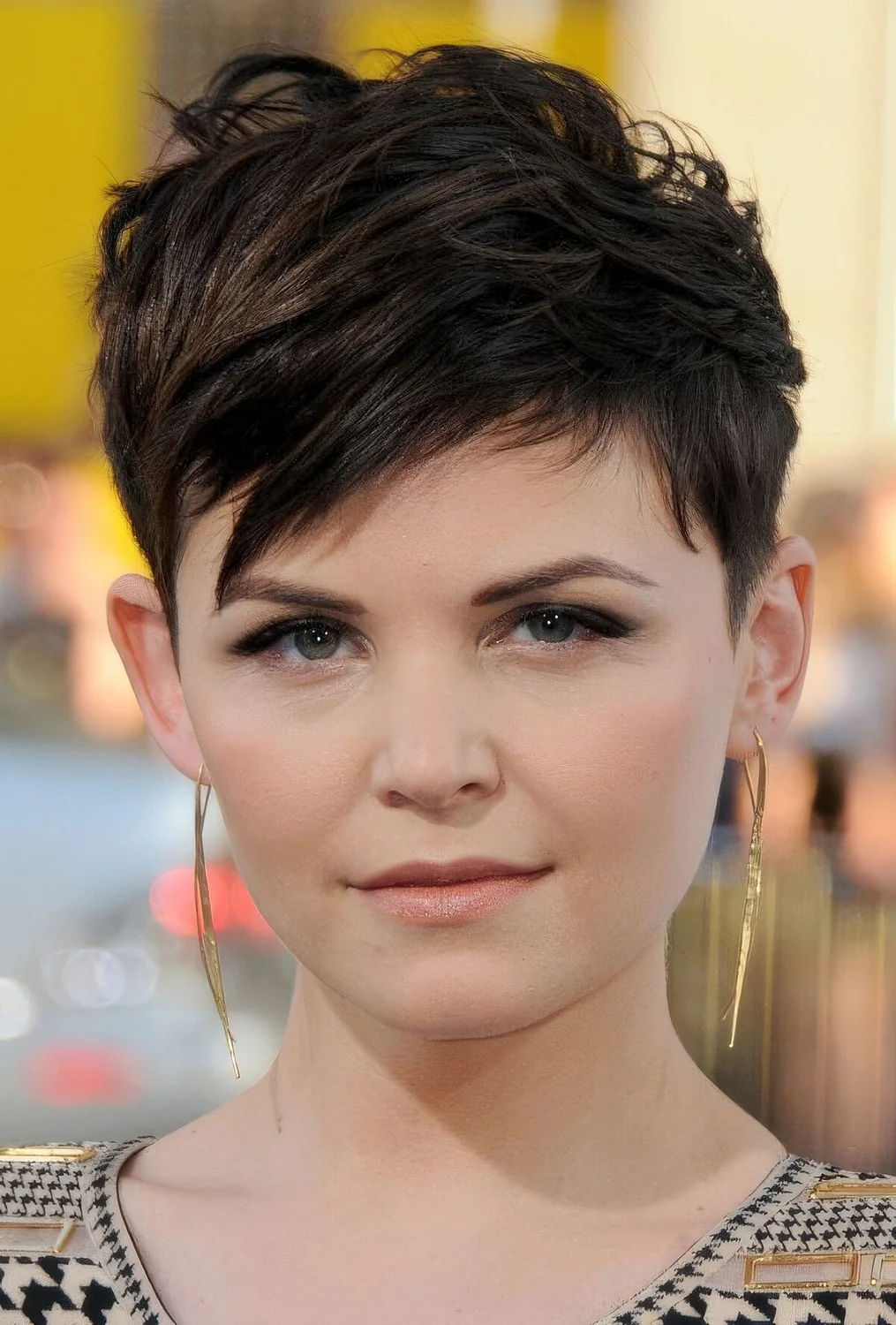 Messy and textured dark brunette long pixie with side bangs and a lot of messy volume.