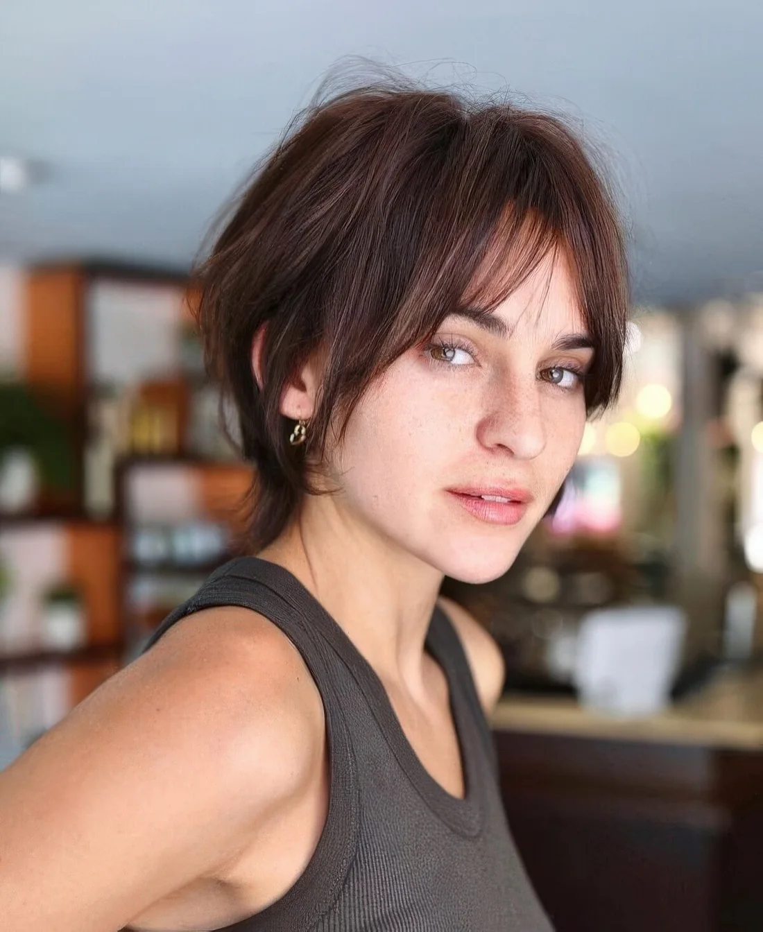 Messy chestnut bixie with bottleneck bangs, longer side hair and texture doesn't require much styling.