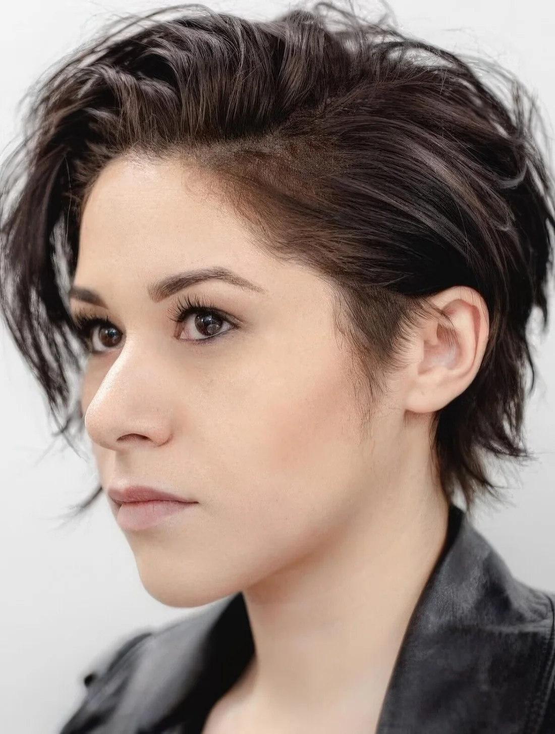 Messy pixie haircut with layers and a long fringe play well with the messy look and give an almost carefree attitude.