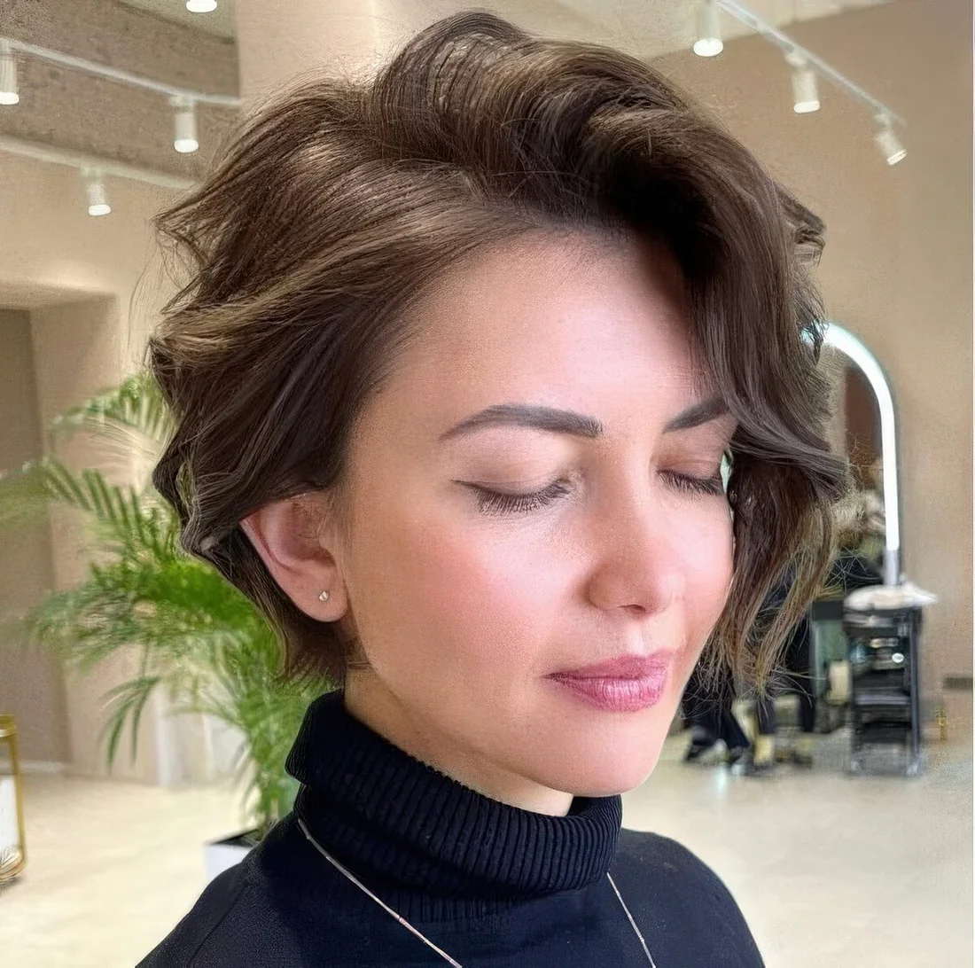 Wavy brown bixie with a lot of volumem and side bangs.