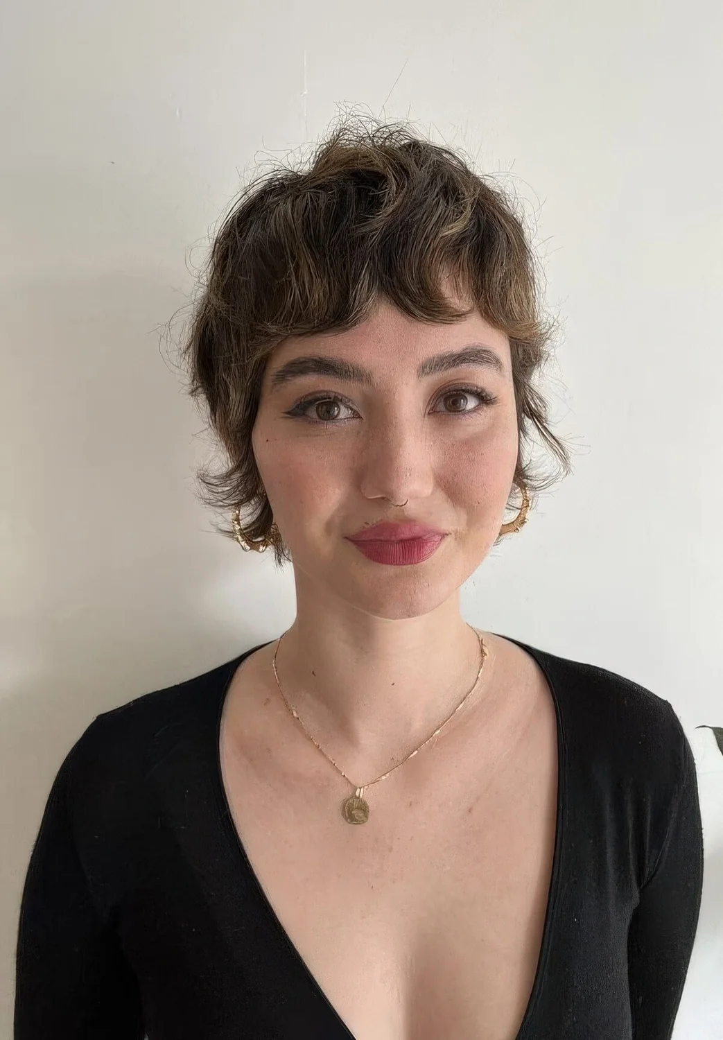 Short brunette mullet on naturally wavy hair.