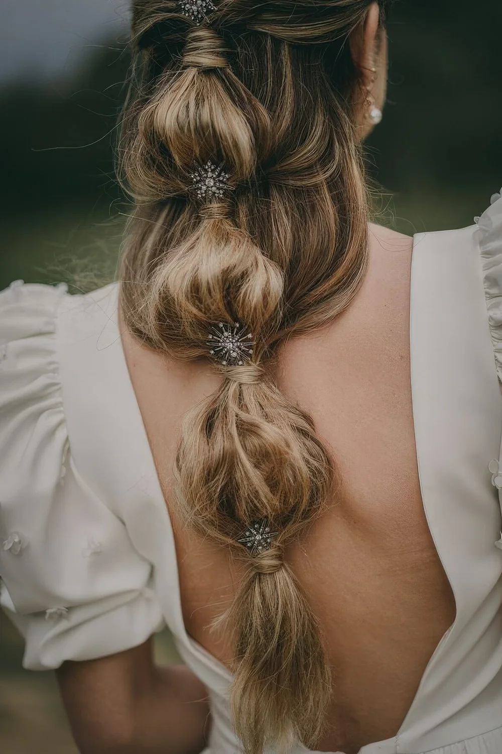 Refined loose bubble braid accented with embellished hair pins.