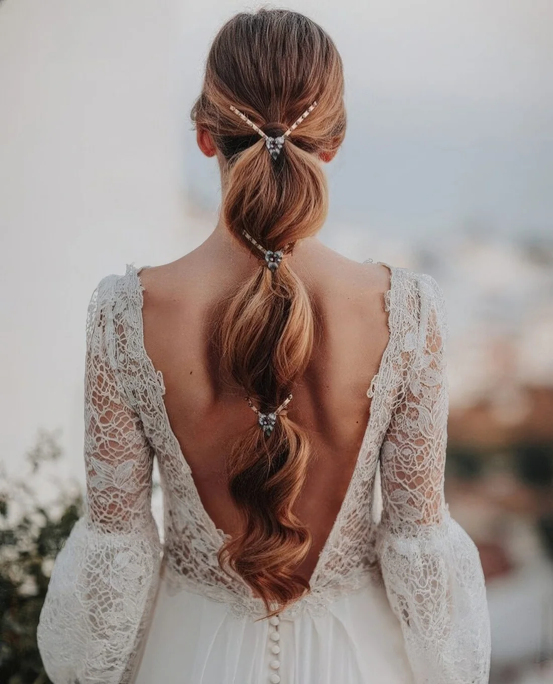Wedding hairstyle of a bubble braid accented with a lovely embellished hair vine.