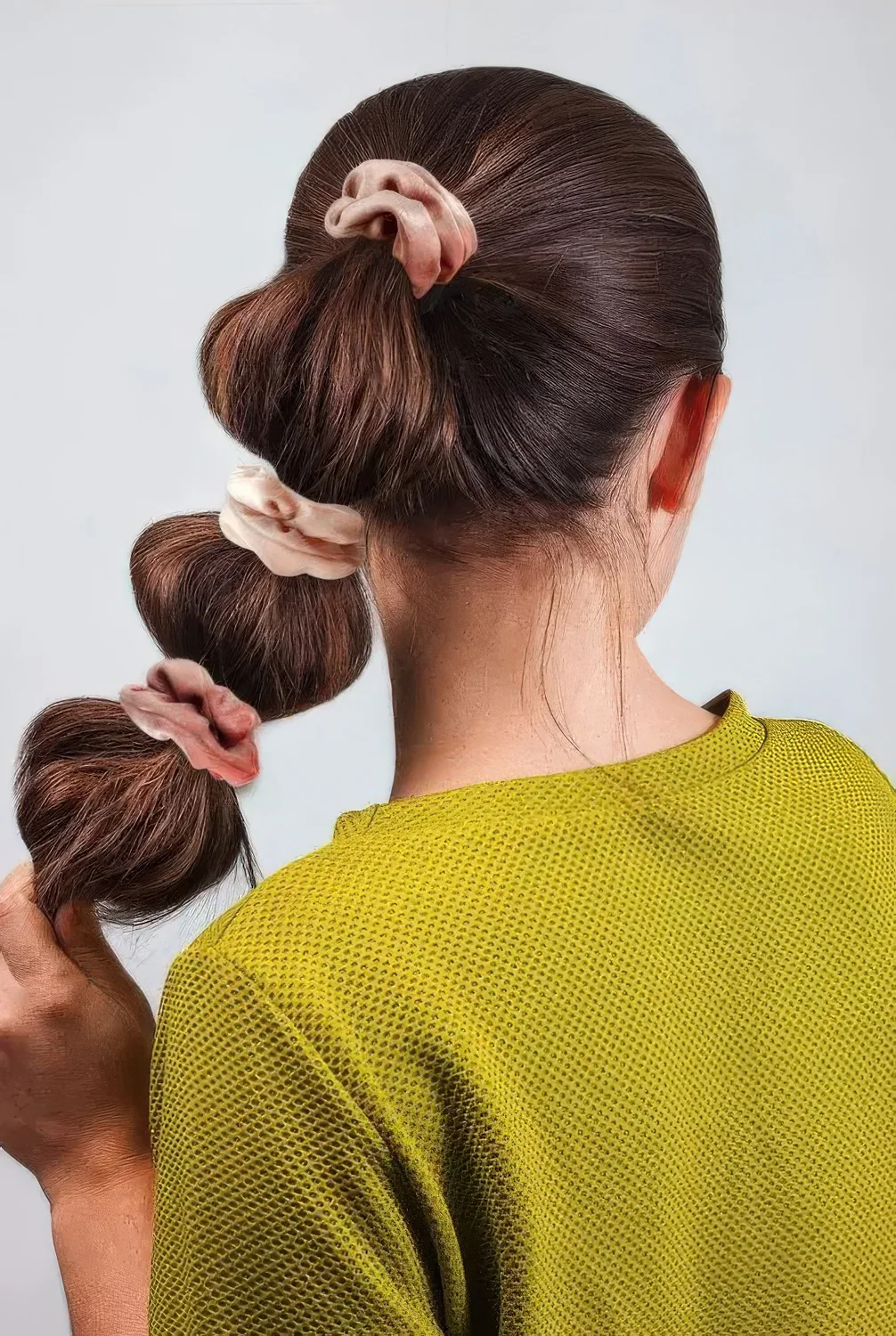 Fun bubble ponytail with a sleek top accented with blush scrunchies.