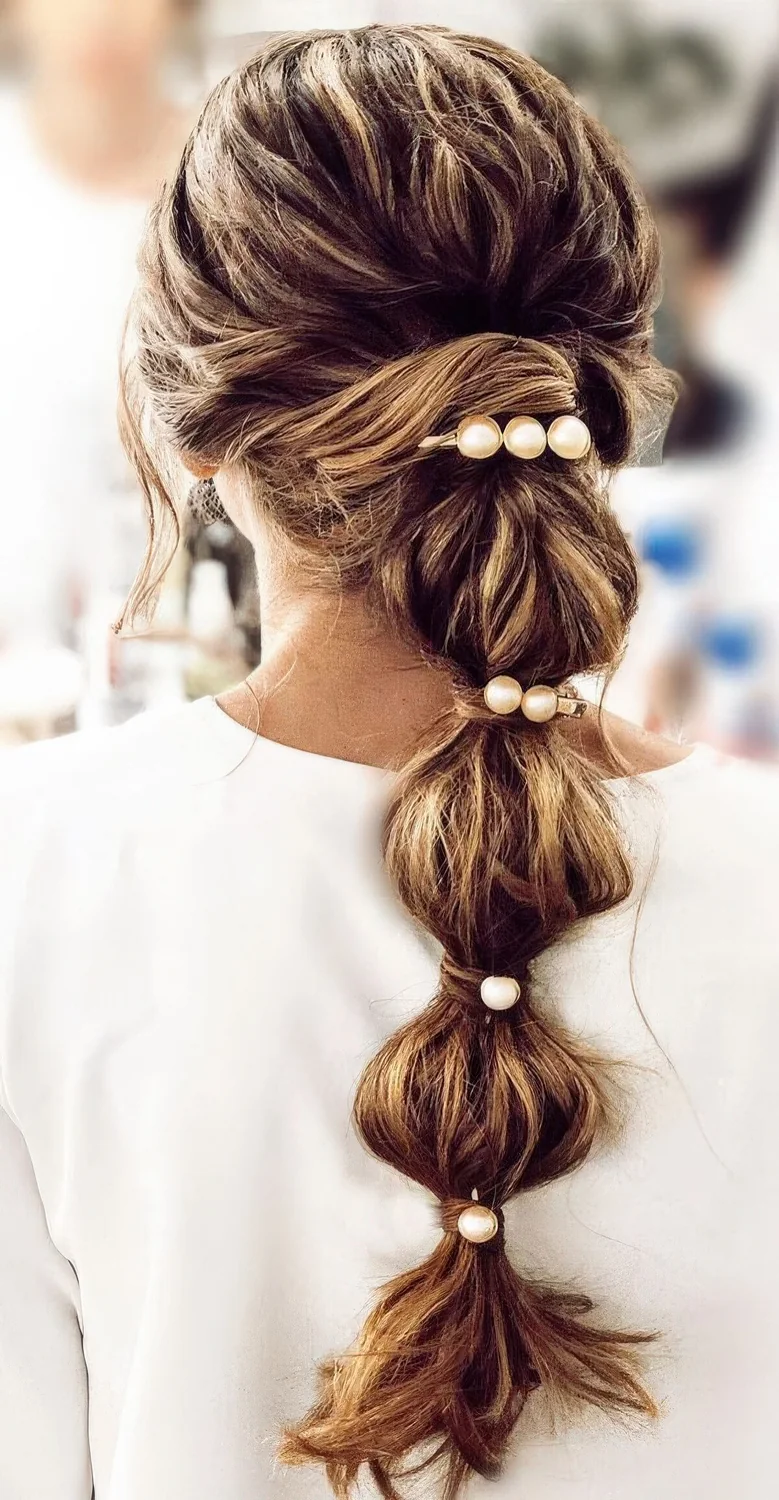 Long and loose bubble braid with a volume on top and some pearl hair pieces.