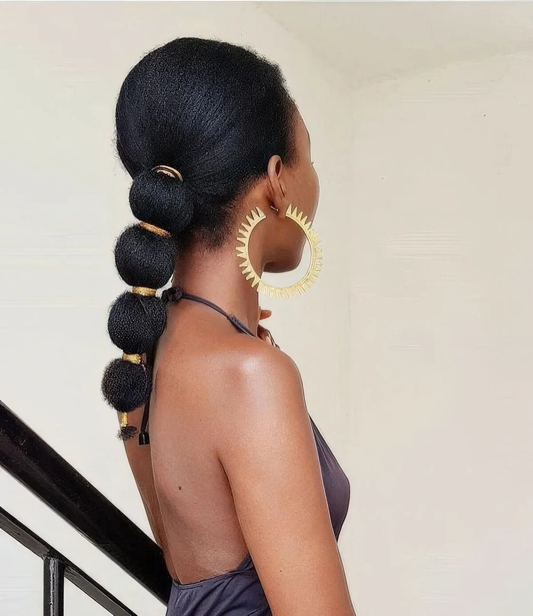 Low volumetric bubble ponytail with a volumetric top and gold elastics.