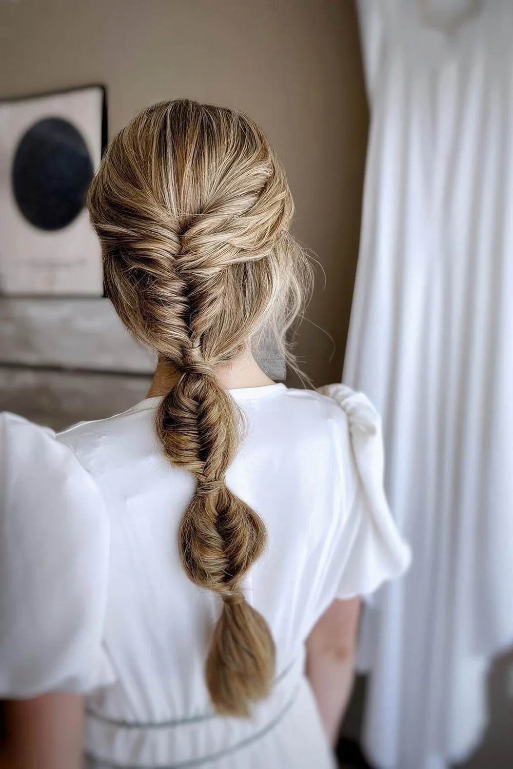 Wedding hairstyle of a bubble and fishtail braid plus a sleek top.