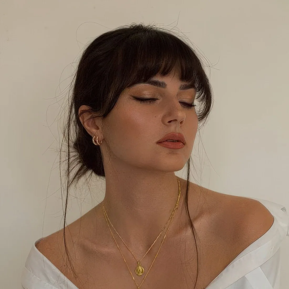 Photo showing low bun with layered bangs, with the hairstyle clearly visible.