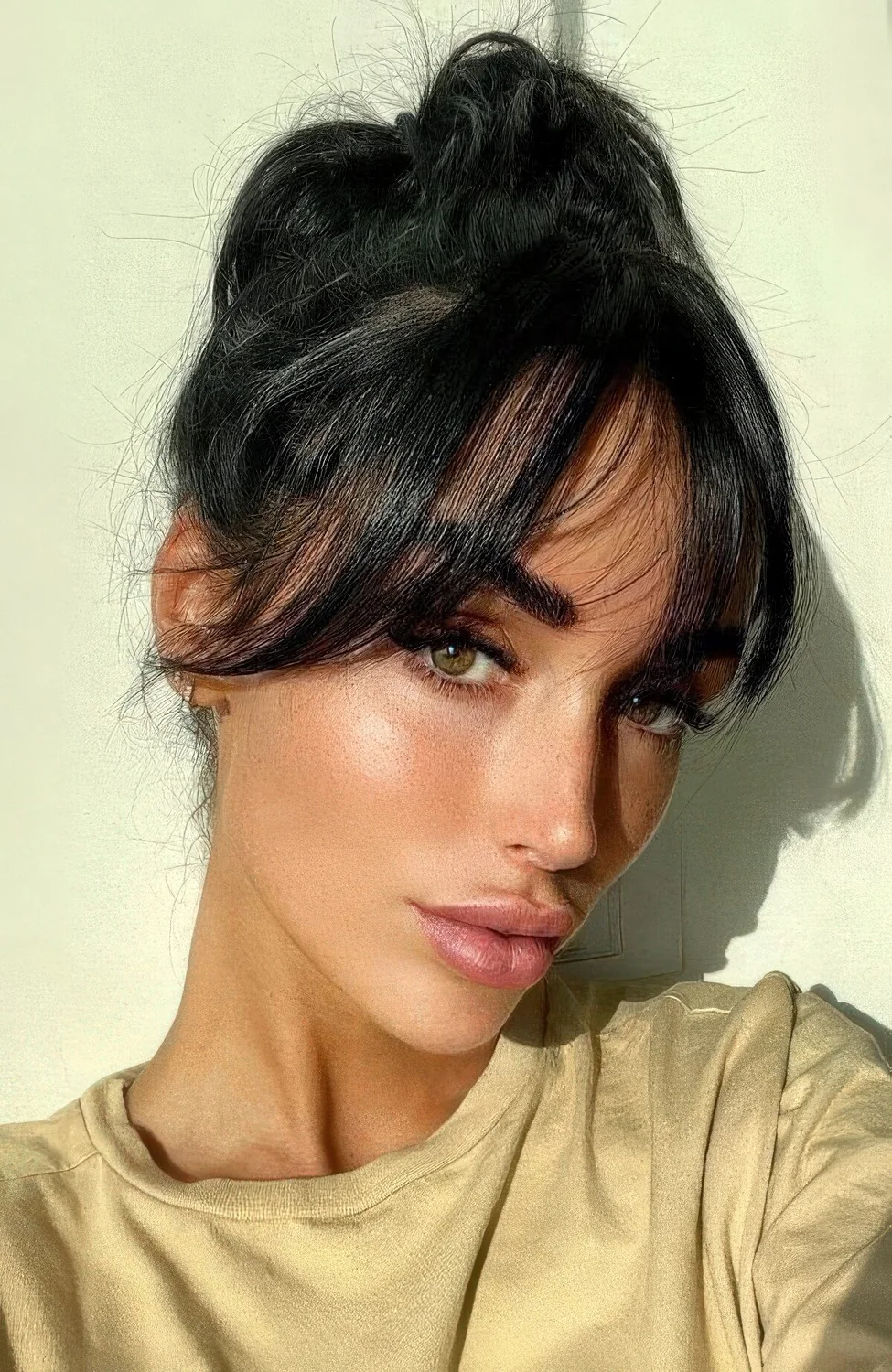 Messy top knot with overgrown bottleneck bangs.