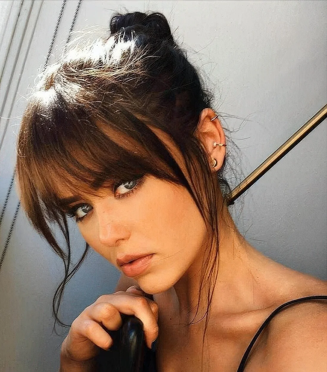 Messy top knot with overgrown classic and curtain bangs.