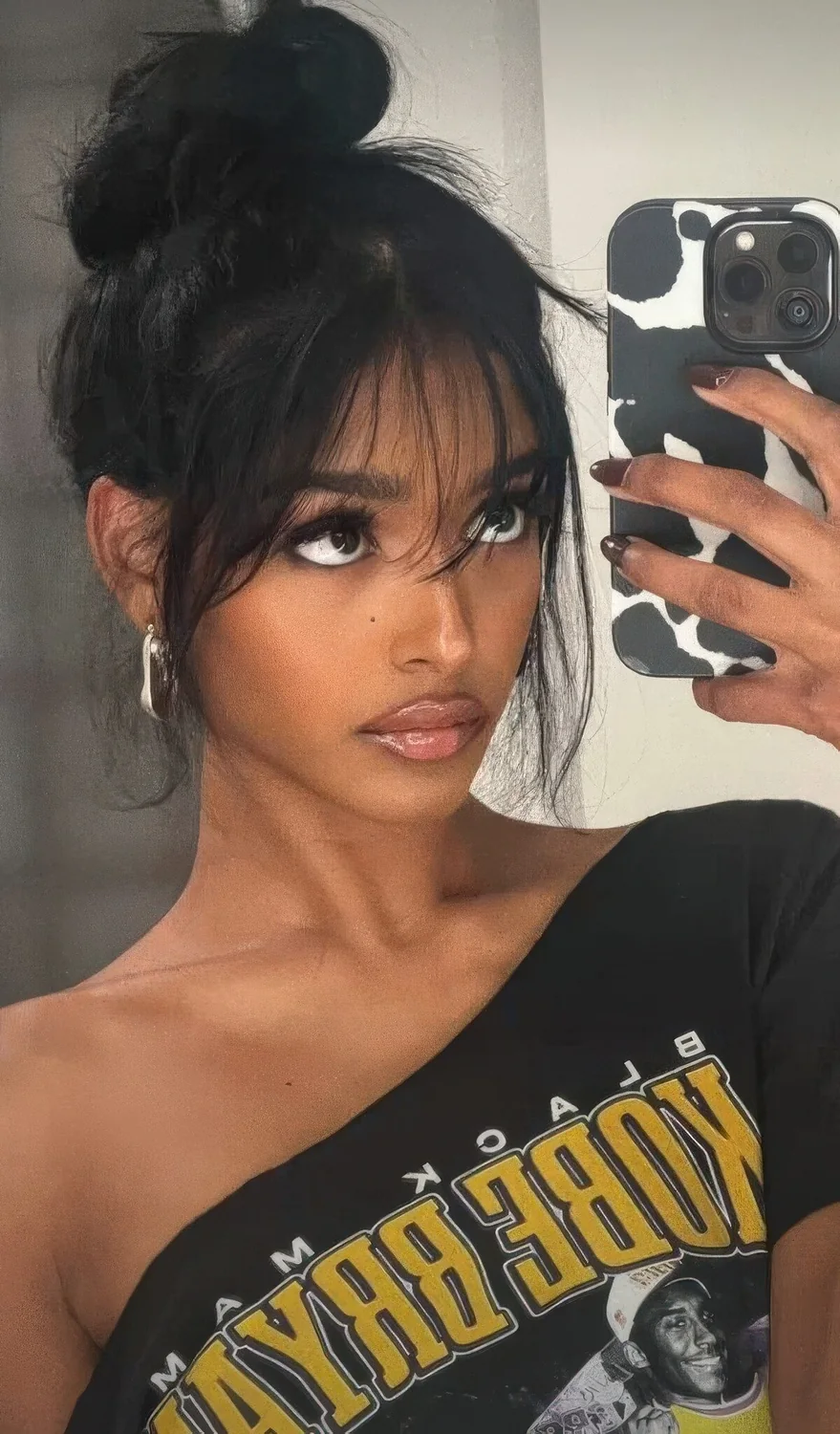 Photo showing messy top knot with wispy bangs, with the hairstyle clearly visible.