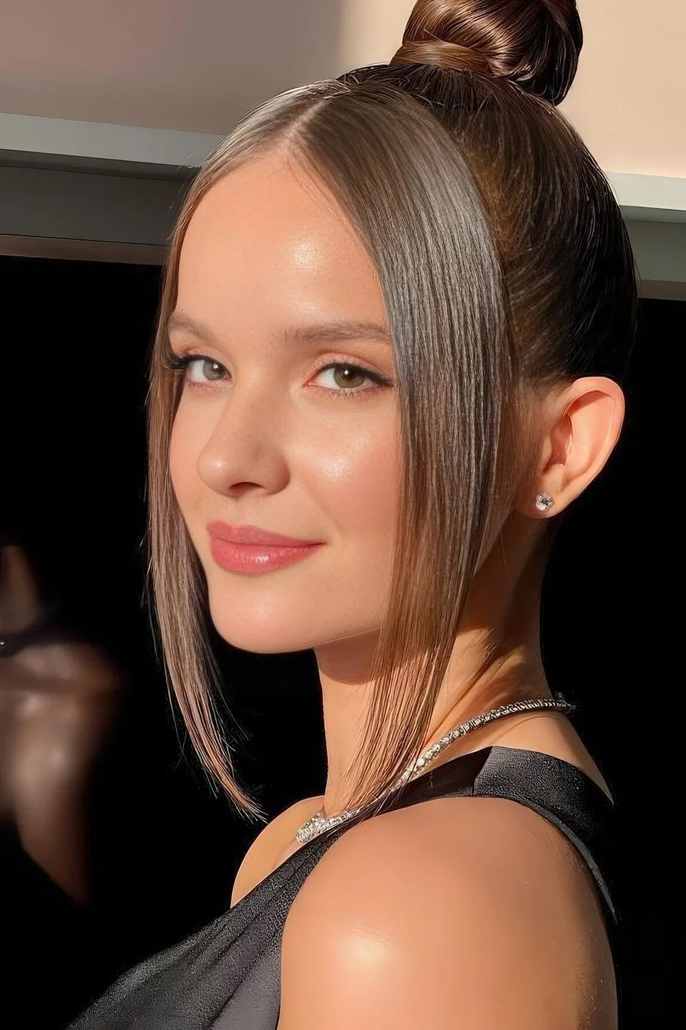 Sleek modern top knot with long curtain bangs.