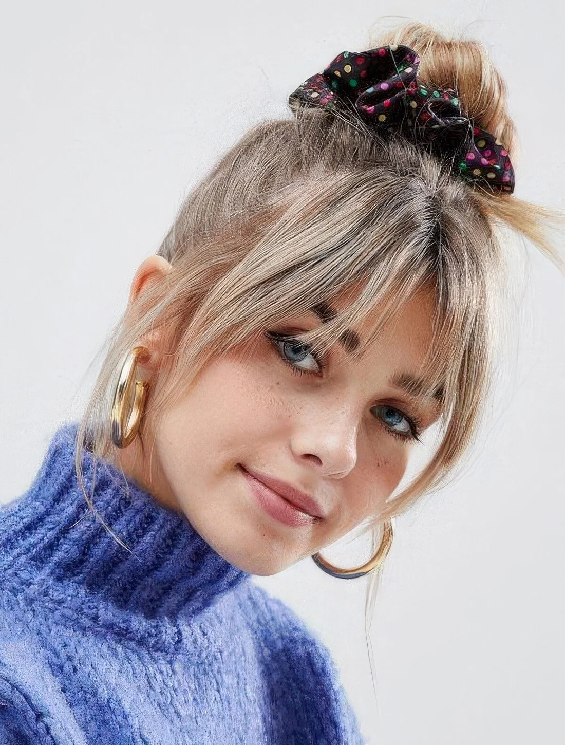 Top knot paired with layered bangs.
