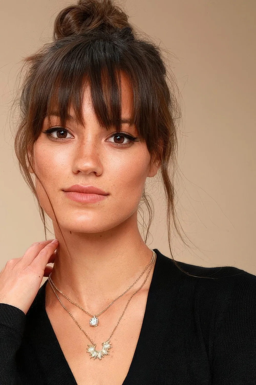 Photo showing top knot paired with wispy bangs, with the hairstyle clearly visible.