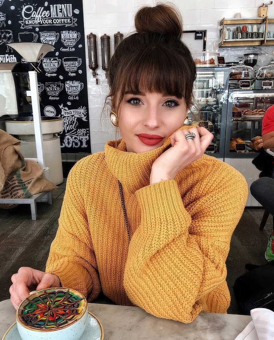 Photo showing top knot with a classic fringe, with the hairstyle clearly visible.