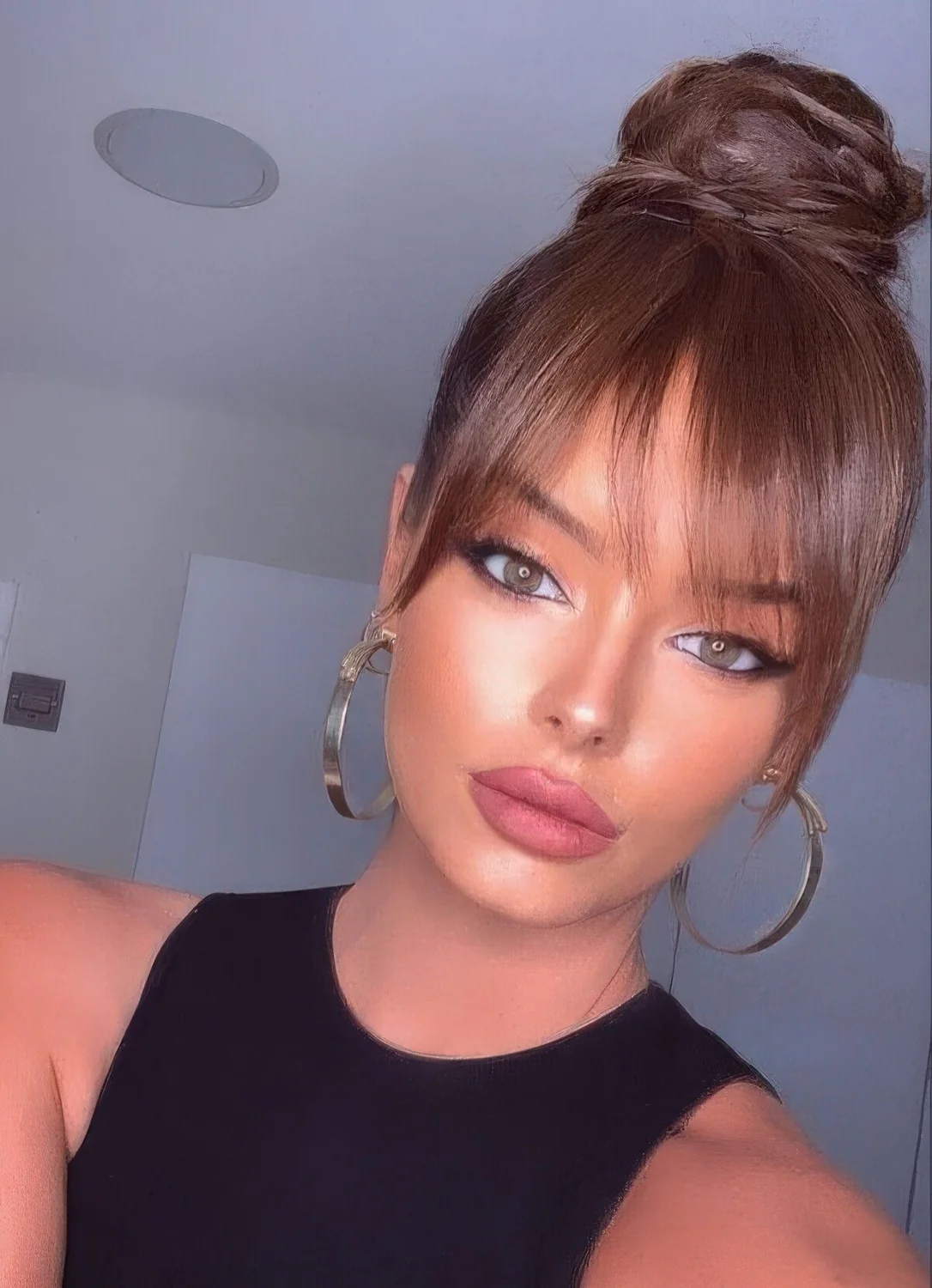 Volumetric braided top knot with long wispy bangs.