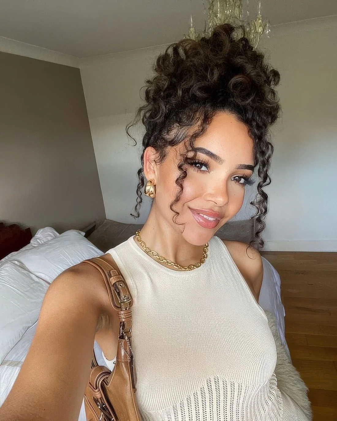 Volumetric curly top knot with curly curtain bangs.