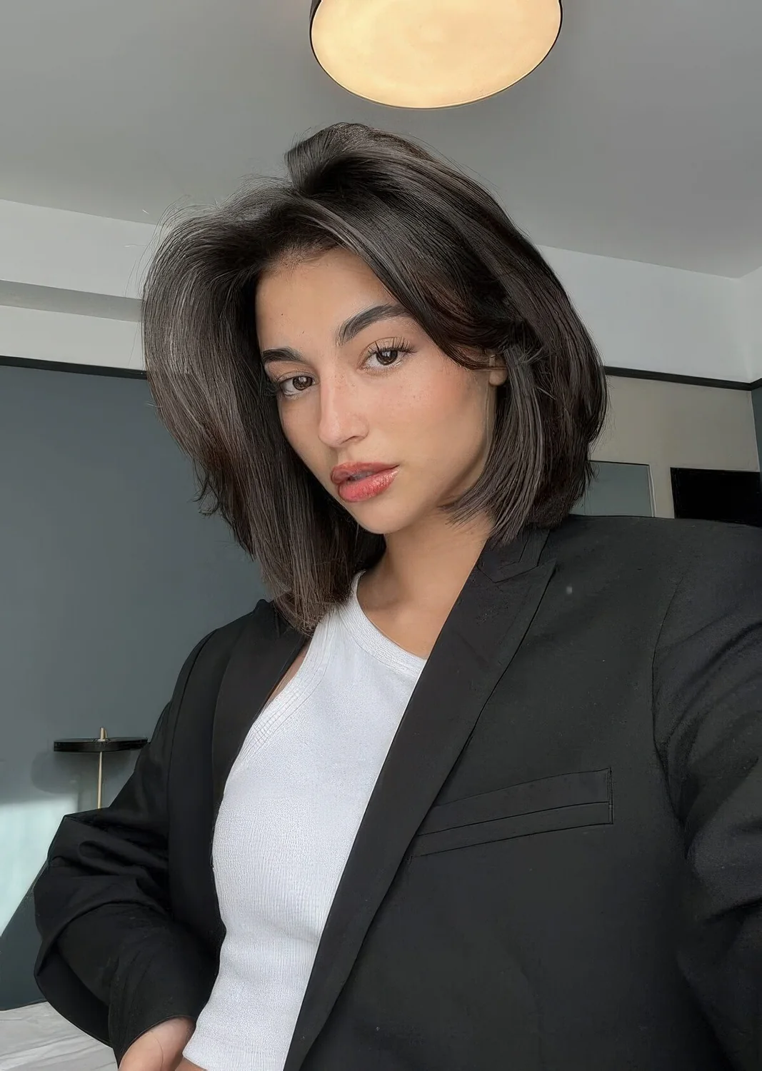 Old Money look with a black butterfly bob with curtain bangs and a lot of volume.