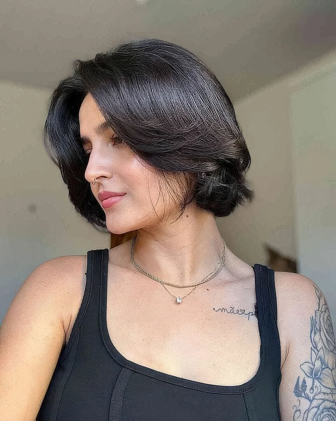 Jaw-length black butterfly bob with center part and some volume and a glossy finish.