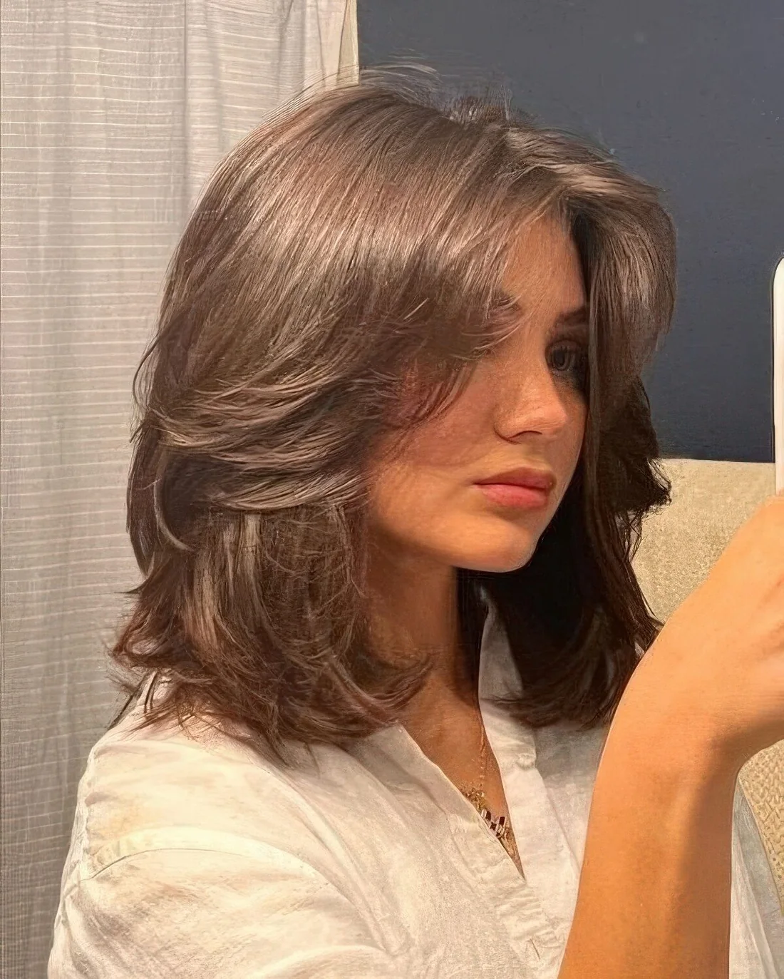 Long chocolate brown butterfly bob with multiple layers and curled ends.